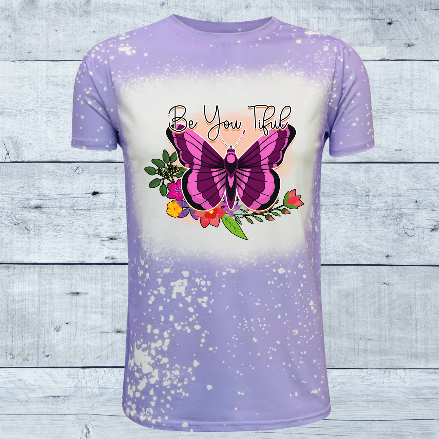 Embrace your unique beauty with our "Be You Tiful Butterfly" faux bleached t-shirt, available in serene shades of pink or lavender. Each shirt is a canvas of creativity, featuring a meticulously crafted faux bleach effect that gives it a distinct, one-of-a-kind appearance. The design centers around a graceful butterfly, symbolizing transformation and individuality, surrounded by delicate swirls and patterns that evoke a sense of whimsy and freedom.