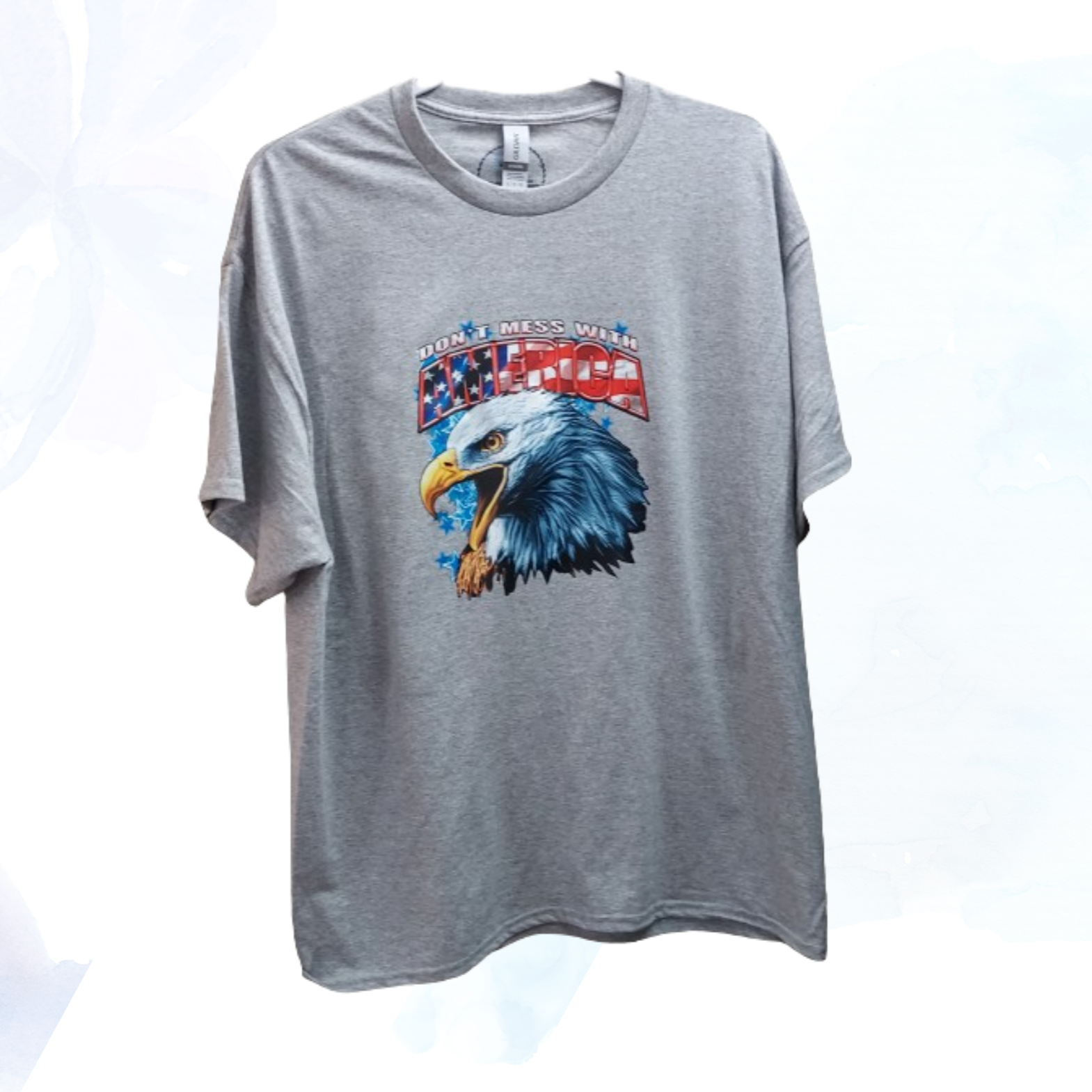 Show your patriotic pride with our "Don't Mess With America" t-shirt!  &nbsp;Crafted from a premium 50/50 blend of cotton and polyester for unmatched comfort and durability. The classic gray hue complements the bold eagle head graphic emblazoned across the chest, symbolizing strength, freedom, and resilience.