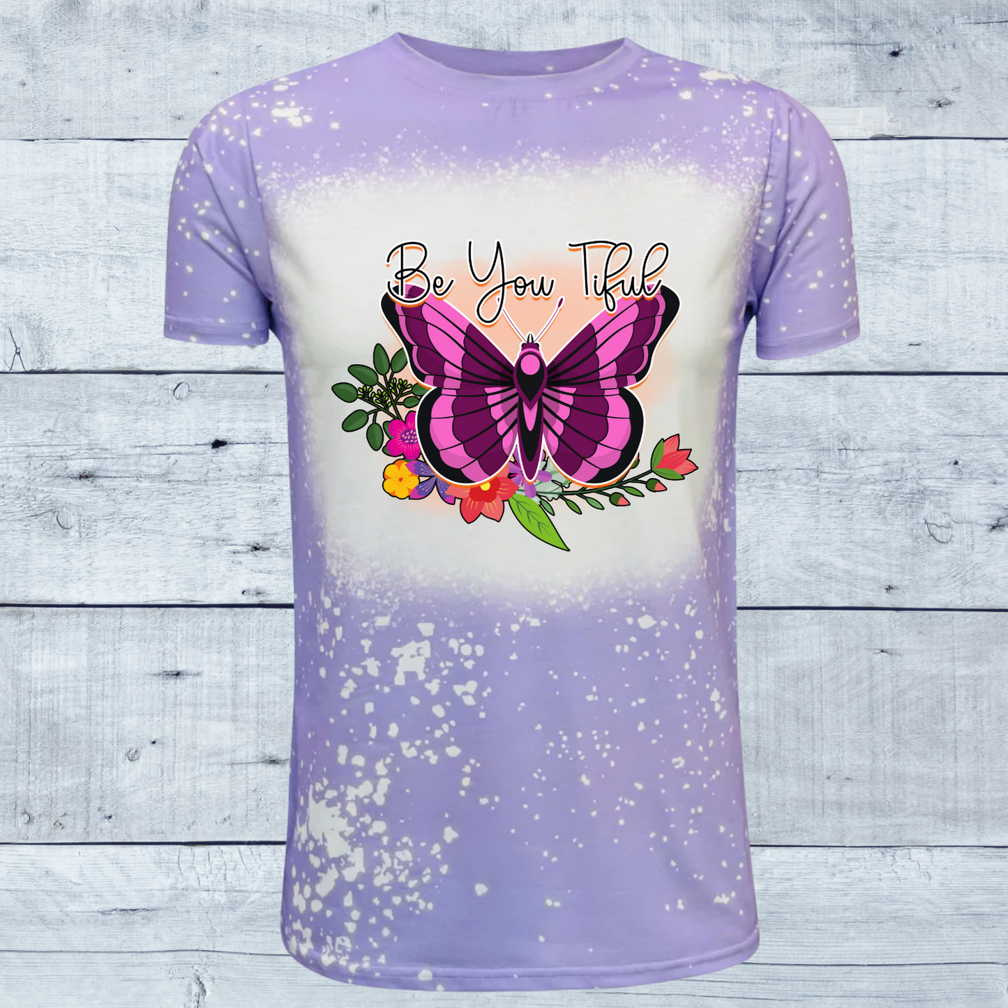 Embrace your unique beauty with our "Be You Tiful Butterfly" faux bleached t-shirt, available in serene shades of pink or lavender.  Each shirt is a canvas of creativity, featuring a meticulously crafted faux bleach effect that gives it a distinct, one-of-a-kind appearance. The design centers around a graceful butterfly, symbolizing transformation and individuality, surrounded by delicate swirls and patterns that evoke a sense of whimsy and freedom.