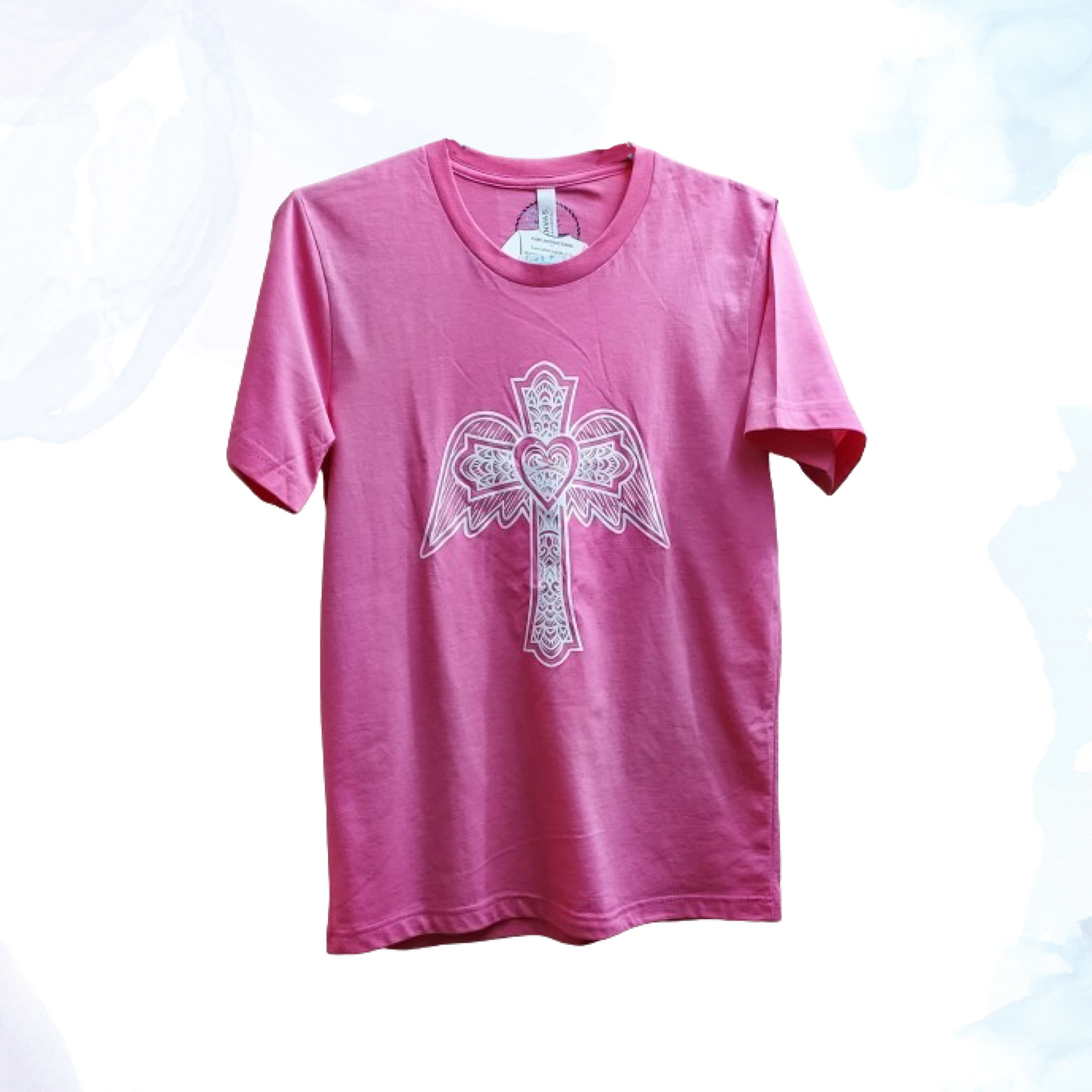 The Glitter Winged Cross Pink Tee, where style meets symbolism in a dazzling display.  &nbsp;This captivating t-shirt blends contemporary fashion with a touch of spiritual inspiration, perfect for those who appreciate both trendsetting design and meaningful motifs.