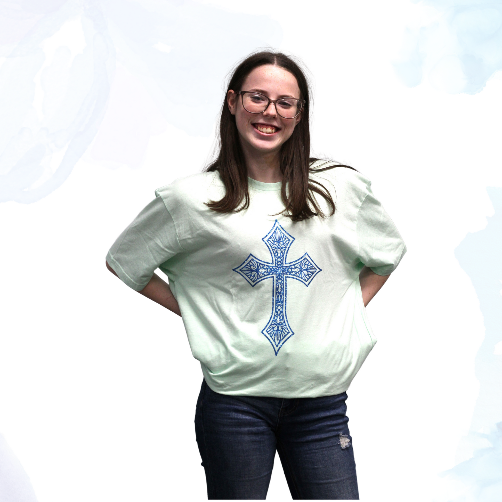 Introducing our Mint Green T-shirt with a Blue Glittery Cross, where comfort meets style in a dazzling blend.  Crafted from premium cotton, this t-shirt ensures a soft and breathable feel, perfect for everyday wear.  The standout feature of this shirt is its eye-catching blue glittery cross design, meticulously placed on the front. The shimmering blue adds a touch of elegance and flair, making this t-shirt ideal for both casual outings and special occasions.